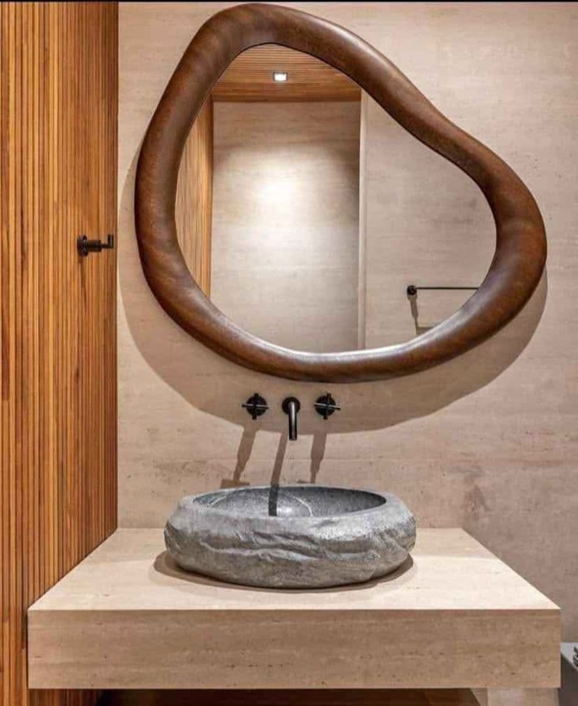 Lavamanos artesanal de piedra de río con borde natural y base pulida en Mortero y Piedra.